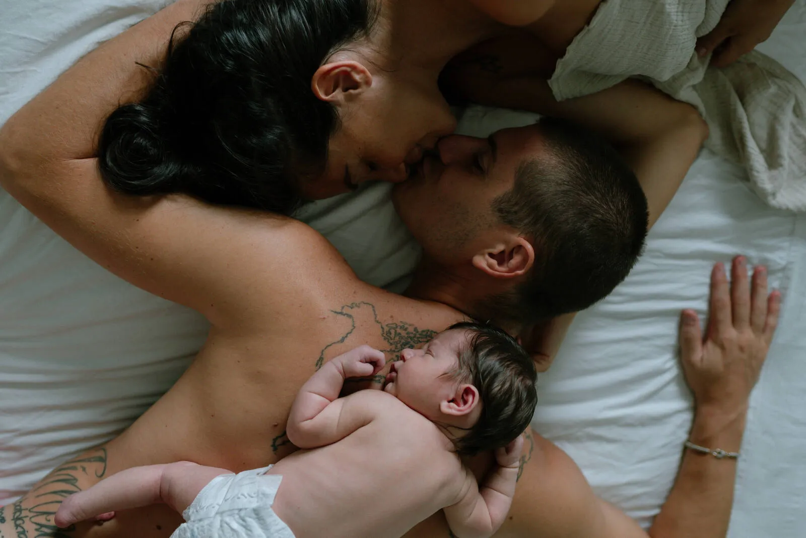Mamma e papà con il loro neonato addormentato, un momento di tenerezza